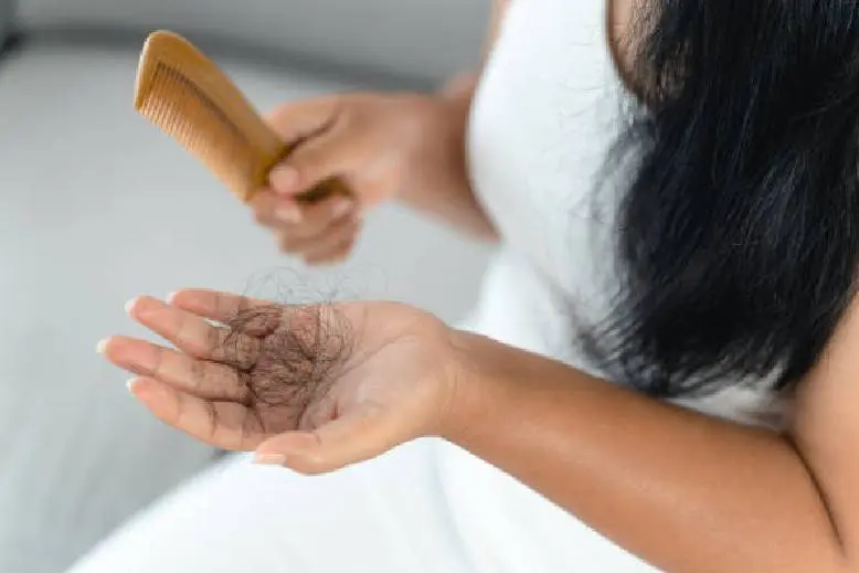 Person holding hair with visible hair loss on palm.